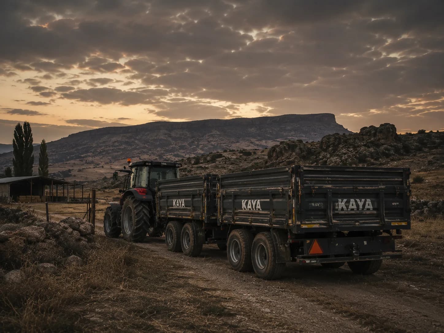 Köy yolunda akşam gökyüzü altında kırmızı Kaya kapaklı damperli römork